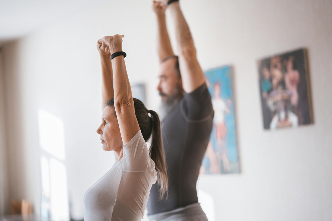 man and woman stretch up and overhead together at the same time.