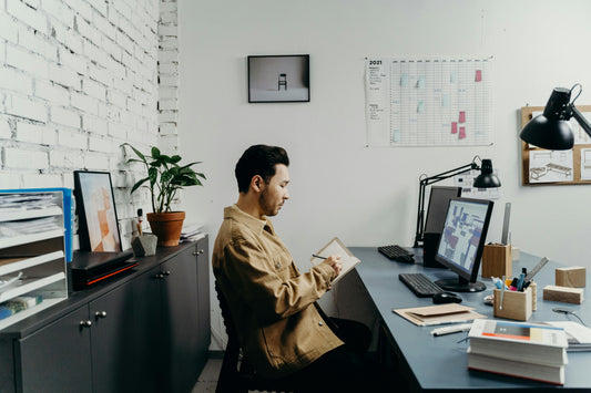 man sitting at his office desk and taking notes