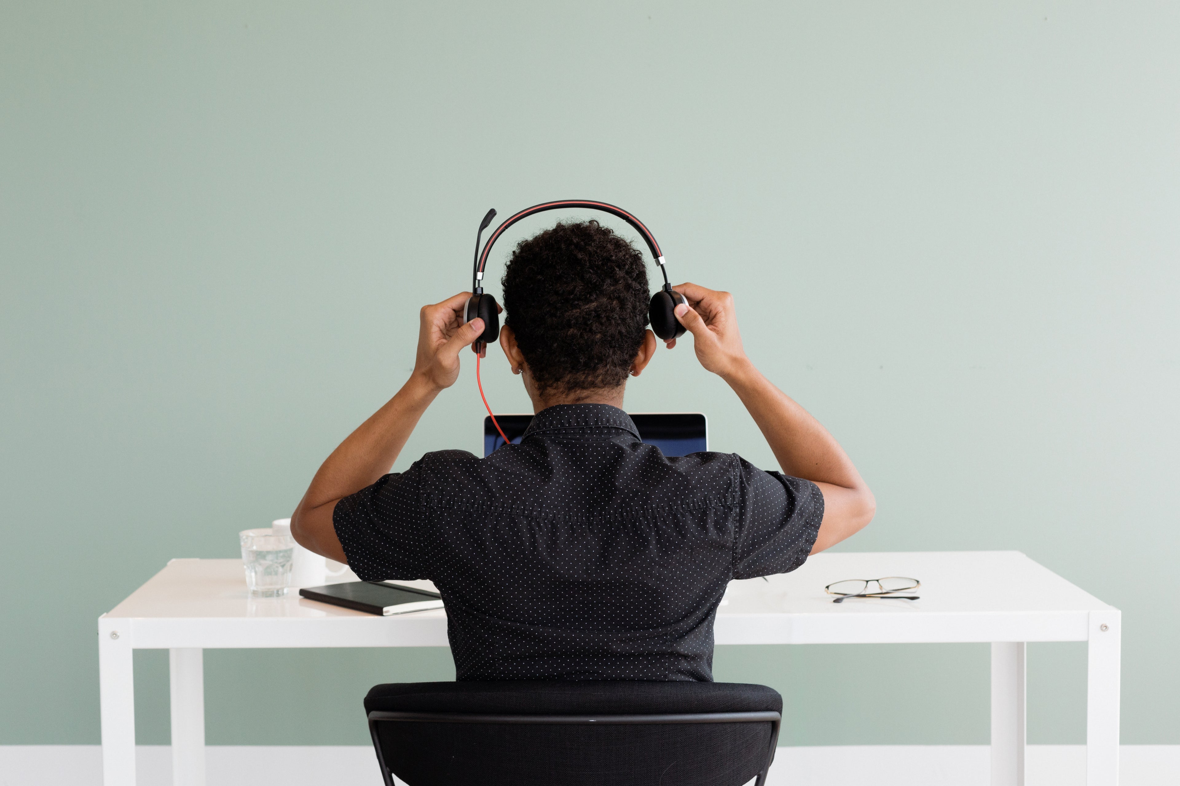 customer support personnel seated at a desk with a computer and a headset. He is awaiting inquiries and can be reached at support@tyltposture.com